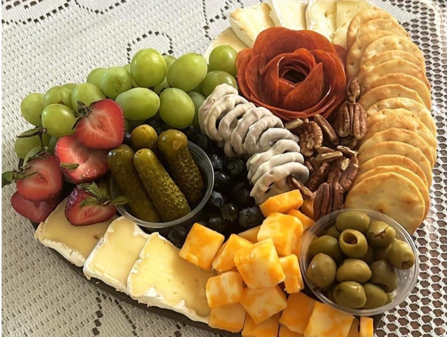 Round charcuterie platter with grapes, pickles and white-chocolate pretzels